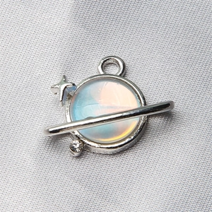 Macro shot of silver planet pendant with colorful opal stone and sparkling star details