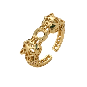 Luxurious gold double leopard head open ring with sparkling green gem eyes on white background