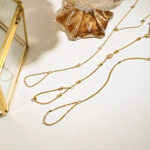Detailed view of layered 18K gold plated bracelets with heart charm and zircon stones