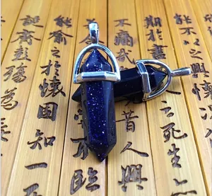 Macro view of blue sandstone hexagonal pendants with silver metal clasps on bamboo