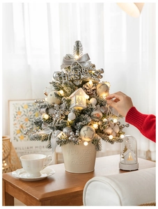 Detail of DIY mini Christmas tree with silver ornaments and warm glowing fairy lights