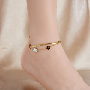 Gold stainless steel layered anklet with white shell clover and flower charms on fabric
