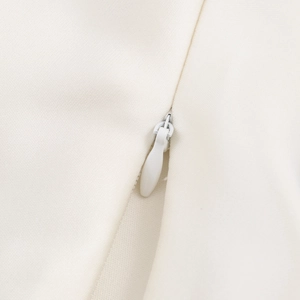 Detail view of high-quality invisible zipper on ivory woven satin bow back blouse
