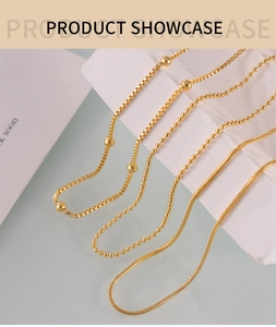 Detailed view of gold plated box, ball, and snake chains on white stone props
