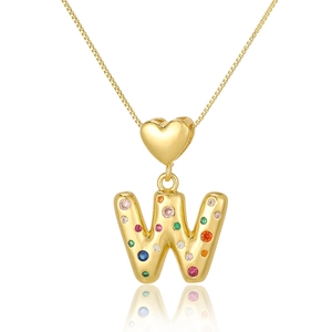 Macro view of gold heart necklace with colorful zircon letter W pendant on white background