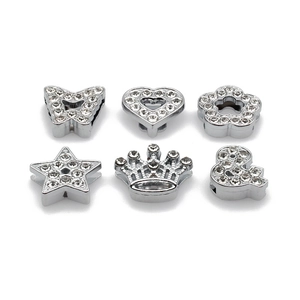 Macro shot of silver alloy slide charms with sparkling white rhinestones in various shapes