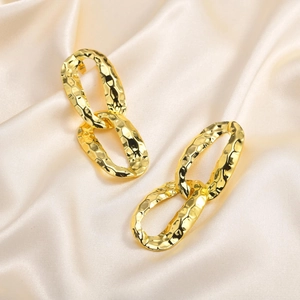 Chic gold-plated hammered double oval link earrings on elegant white satin fabric