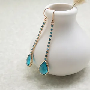 Elegant gold drop earrings featuring blue teardrop crystals and long zircon tassels