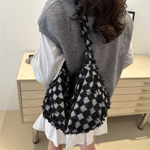 Large capacity black and white checkerboard tweed tote bag with fringe details on model