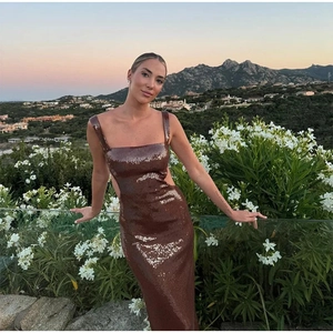 Close-up of a shimmering dark brown sequined sleeveless evening dress in sunset light