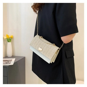 Detail showing the woven texture and PU leather stitching on a mini crossbody bag