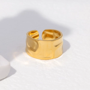 Macro view of wide gold stainless steel ring featuring irregular hammered texture details
