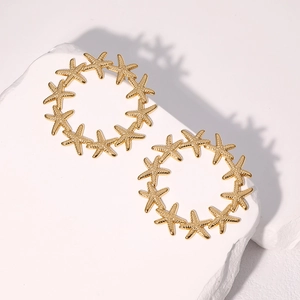 Elegant gold starfish hoop earrings made of stainless steel on white textured stone