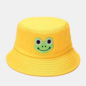 Close-up of cute green frog embroidery on a bright yellow cotton bucket hat with stitching