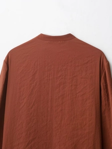 Detailed back view of rust red shirt neckline with micro-wrinkle textured fabric