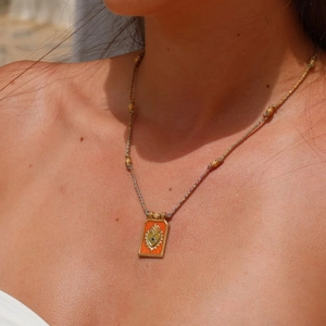 Tarot heart pendant necklace with orange enamel, eye motif, and colorful woven cord