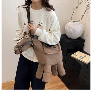 Detailed view of horse-shaped brown canvas crossbody bag with decorative harness details