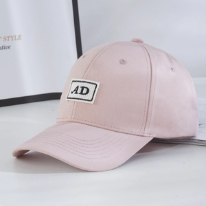 Detail of light pink 6-panel baseball cap showing black and white AD embroidery logo