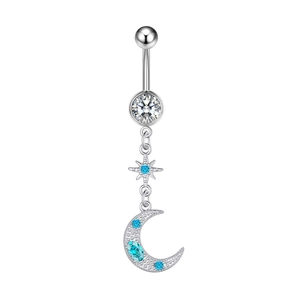 Macro detail of silver navel ring with zircon star and blue moon charms on white background