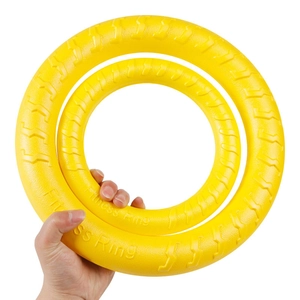 Detail showing two yellow foam fitness rings for dogs held to demonstrate size and texture