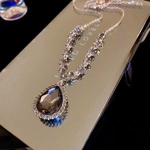 Vue rapprochée du collier en cristal goutte marron fumé avec des détails pavés