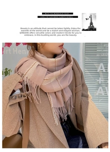 Close-up of pink and beige checkered cashmere scarf with soft tassels on camel coat