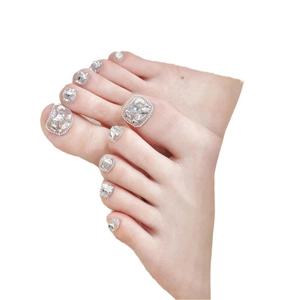 Unghie finte piedi bianche eleganti con glitter argento e decorazioni in strass di lusso