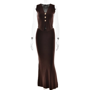 Detail of dark brown knit set with gold buttons on the vest and slim-fit maxi skirt