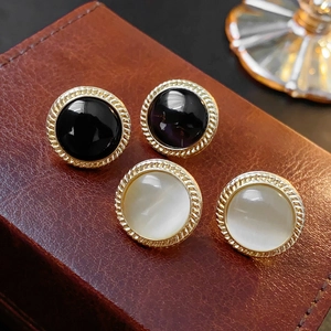 Detail of vintage round cat eye stone and black bead earrings in gold twisted frames