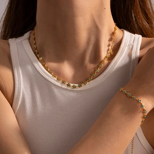 Set collana e bracciale dorati con fiori e perle azzurre in stile estivo chic