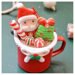 Close-up of a festive red cup ornament featuring Santa, a Christmas tree, and candy canes