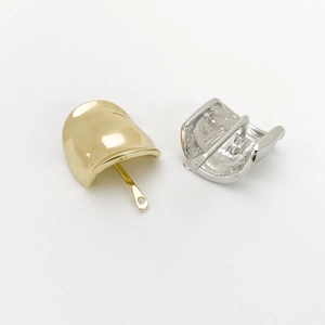 Macro shot of gold and silver metal earring backs with pins on a white background