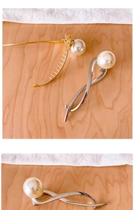 Close-up of elegant gold and silver metal hair clips with large pearl embellishments