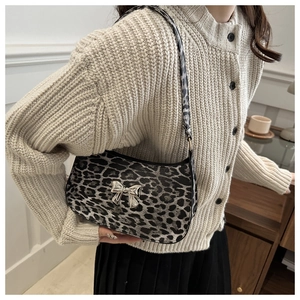 Detail of silver metallic bow on leopard print baguette shoulder bag with soft texture