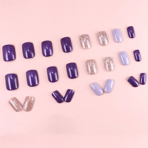 Short square purple nails with glitter sequins and champagne pink accents on a soft background