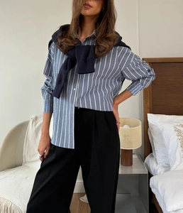 Détail d'une chemise en coton à rayures bleues et blanches avec col boutonné classique