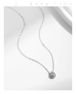 Detail of silver drop-shaped necklace pendant with shimmering small diamonds