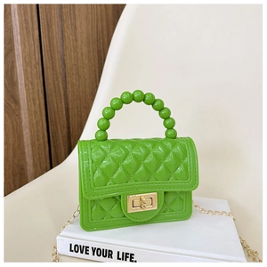 Detail of green jelly PVC bag with classic quilted pattern and gold chain strap