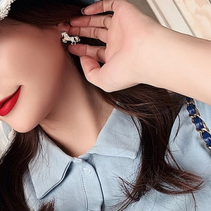 Detail of horse-shaped diamond stud earring worn by model in a side profile view