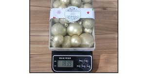 Detailed scale view showing the 183.9g weight of champagne gold Christmas ball set