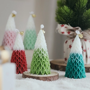 Christmas tree scented candles with snow texture and gold bell decorations for holidays