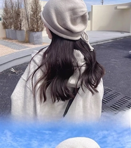 Detail of grey knitted drawstring beanie featuring decorative handcrafted side knots