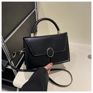 Détail du sac en cuir PU noir avec boucle en métal doré et poignée ronde élégante