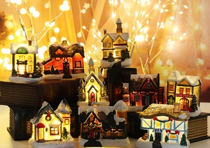 Miniature resin Christmas village set with LED lights on vintage books background