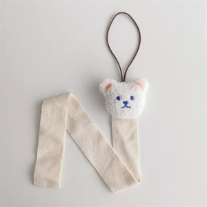 Detail of bear hair clip organizer with beige herringbone strap and plush bear head