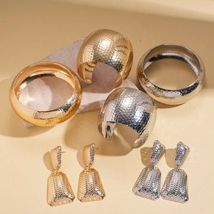 Three-piece set of textured gold and silver metal open bangles and geometric earrings