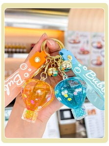 Close-up of hot air balloon keychains with liquid, sequins, and golden bells