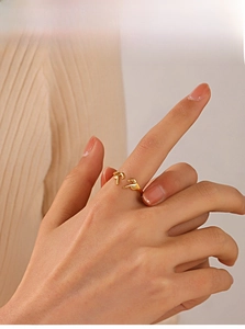 Macro detail of gold-plated heart-shaped hands ring with polished finish on finger