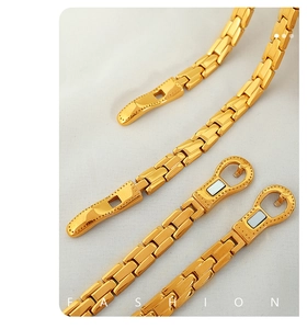 Detail eines goldenen Kettenarmbands mit polierten Gliedern und Magnetverschluss