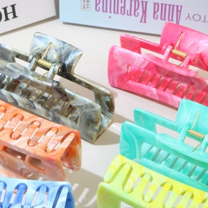 Flat lay of diverse marble-textured and solid color ABS flower hair claw clips for women